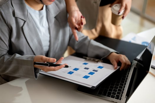 A businesswoman and her boss are working and checking a business report in the office together. photo