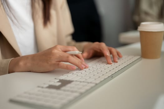 Close-up image of a businesswoman working at her desk in the office, typing on keyboard computer. photo