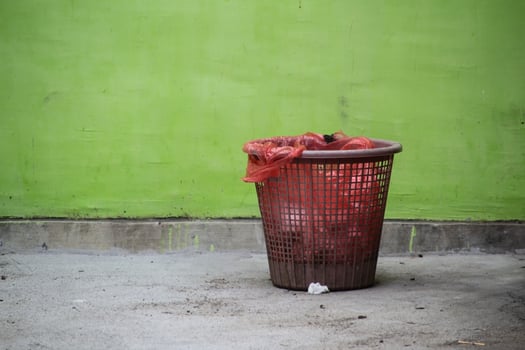 Red Trash Can with Green background and empty space photo