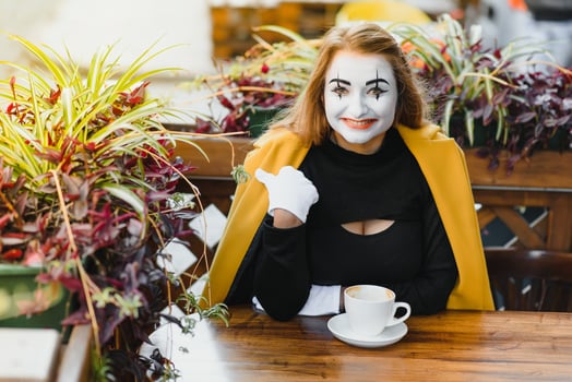 Mime comedian drinking coffee. girl mime drinks coffee in paris. photo