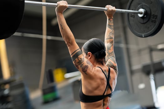 Rear view of a strong fit woman lifting barbell photo