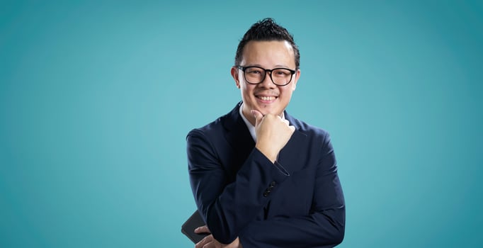 Confident businessman smiling against blue background photo