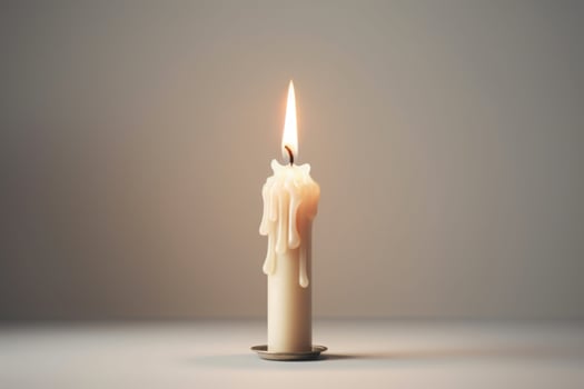 White small candle on white background. The fire is burning. Wax flows. Metal stand for candle. White floor and wall. photo