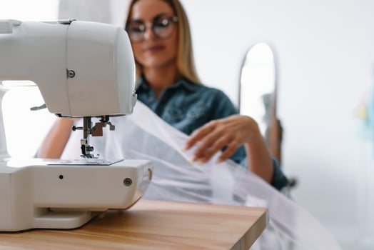sewing machine, pink fabric and women's hands photo