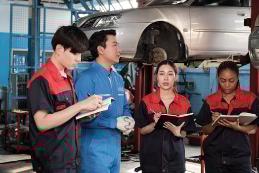 Specialist lecture. Male supervisor engineer describe automotive suspension fixing with mechanic worker staff teams for repair work at car service garage and maintenance jobs in automobile industry. photo
