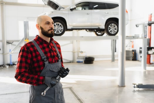 Mechanic working and holding wrench of service order for maintaining car at the repair shop photo