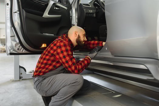 Mechanic working and holding wrench of service order for maintaining car at the repair shop photo