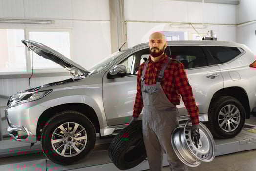 Mechanic holding a tire tire at the repair garage. replacement of winter and summer tires. photo