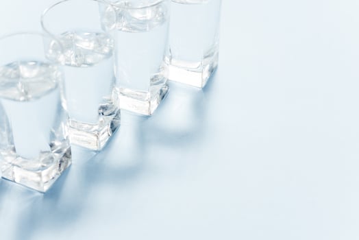 Water filters. Carbon cartridges and glasses on a blue background. Household filtration system. photo