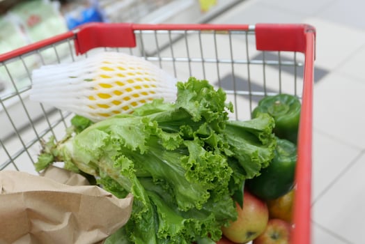 Shopping cart with many foods in a corridor in the supermarket photo