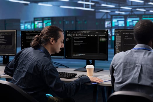 Coworkers in data center workspace running system diagnostic tests to do repairments. IT experts at PC desk in server hub deploying error checking utilities to fix network issues photo