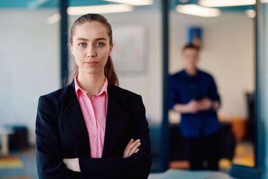 Portrait of a business woman in a creative open space coworking startup office with crossed arms. Successful businesswoman standing in office with copyspace. Associates work in the background photo