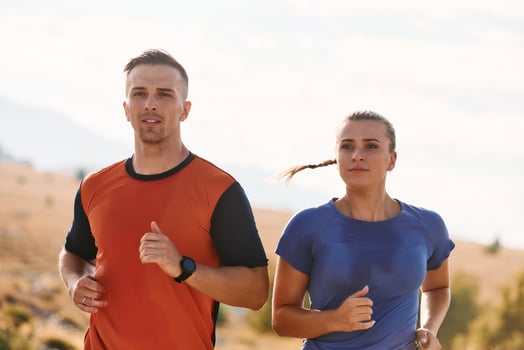 A couple dressed in sportswear runs along a scenic road during an early morning workout, enjoying the fresh air and maintaining a healthy lifestyle photo