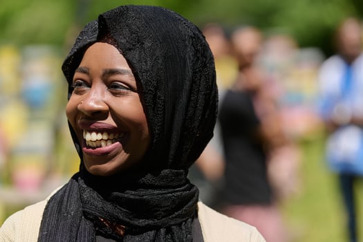 Joyful Middle Eastern Muslim Woman in Hijab Smiling Brightly in a Natural Apiary photo