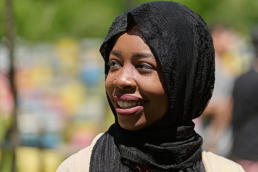 Joyful Middle Eastern Muslim Woman in Hijab Smiling Brightly in a Natural Apiary photo