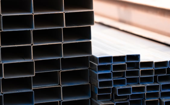 Industrial warehouse stock of rectangular metal pipes for building and construction supplies. Stack of steel pipes. Iron materials for construction and infrastructure projects. Steel tubing storage. photo