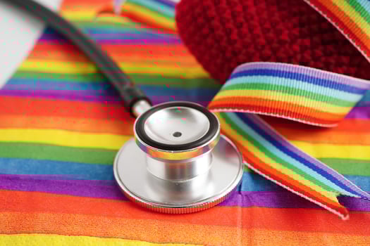 LGBT symbol, Stethoscope with red heart on rainbow flag, rights and gender equality, LGBT Pride Month in June. photo