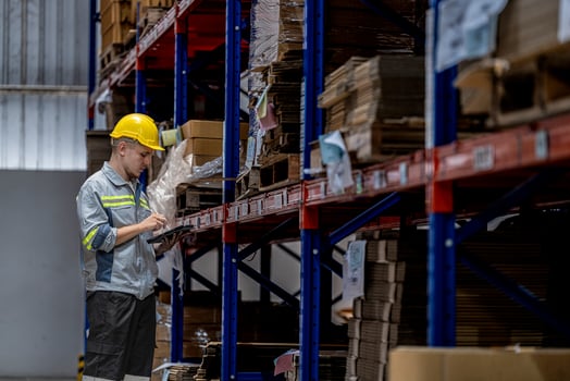 man worker walking and checking stock items for shipping. male inspecting the store factory. Logistics employees holding folders at on site warehouse area for shipping transportation. photo