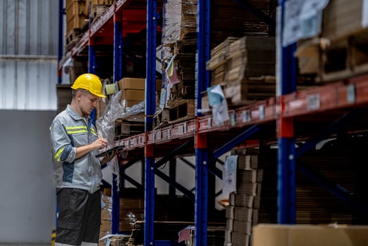 man worker walking and checking stock items for shipping. male inspecting the store factory. Logistics employees holding folders at on site warehouse area for shipping transportation. photo