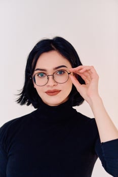 Smiling Brunette Woman Wearing Eyeglasses Poses on White Background photo