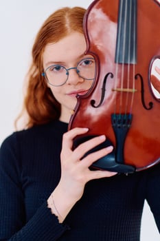 Stunning Redhead Musician Poses with Violin in Captivating Portrait photo