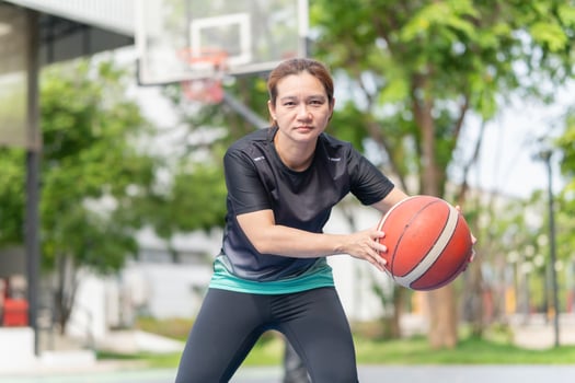 Active Asian woman playing basketball in the urban outdoor basketball court, Healthy life concepts photo