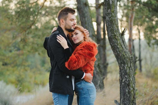 love, relationship, family, season and people concept - smiling couple hugging over autumn natural background. photo