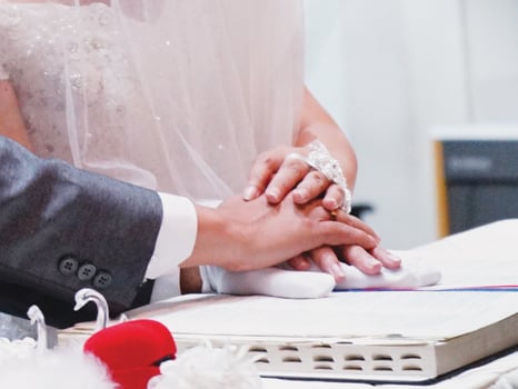 Bride and groom holding Bible. The bride and groom place their hands on the Bible to exchange vows during the church blessing. Christian-Catholic marriage. photo
