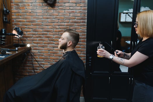 Client during beard shaving in barber shop photo
