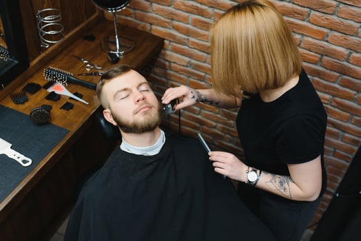 Client during beard shaving in barber shop photo
