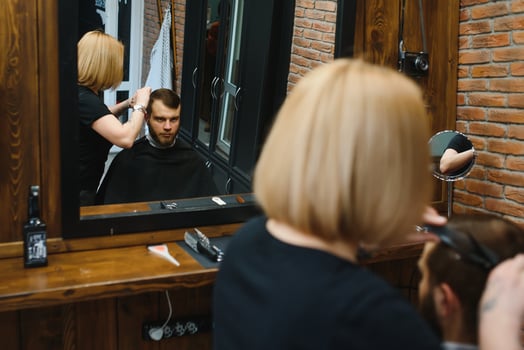 Barber Woman Cutting Man Hair at the Barbershop. Woman Working as a Hairdresser. Small Business Concept. photo