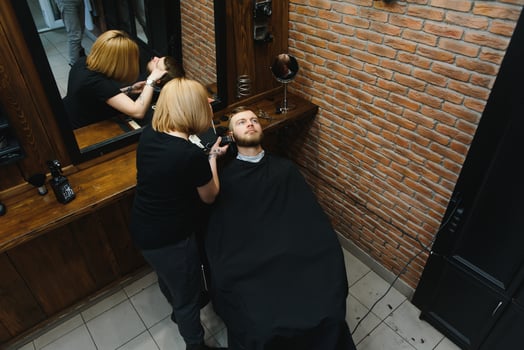 Client during beard shaving in barber shop photo