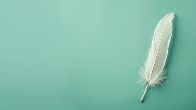 Elegant feather quill pen on a serene mint green background, ideal for creative copyspace photo
