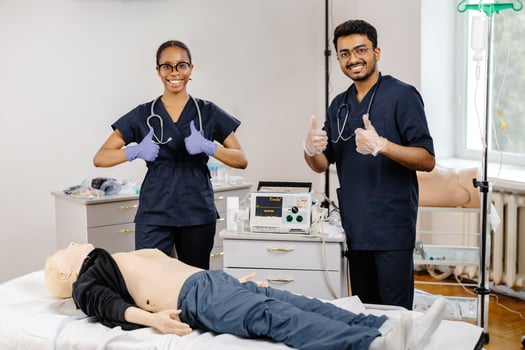 Two medical students practice CPR on a mannequin in a hospital room photo