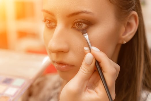 Make-up artist working with brush on model eyes Close up of applying make up on young girl,semi profile, professional make up in beauty studio photo
