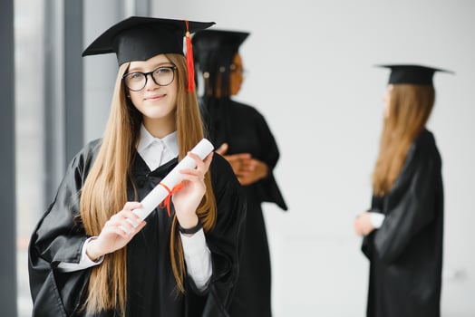 Beautiful female graduate standing out from a group of students photo