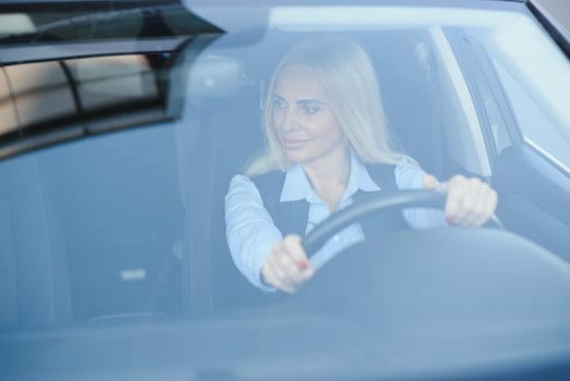 Businesswoman sitting in drivers seat in her car photo