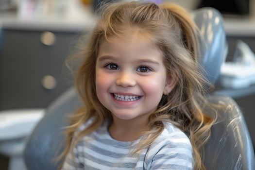 smiling girl at a dentist appointment sitting in a dental chair photo