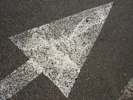 a white arrow painted on the road photo