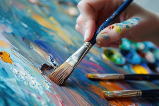 Someone is painting with a brush on a colorful surface photo