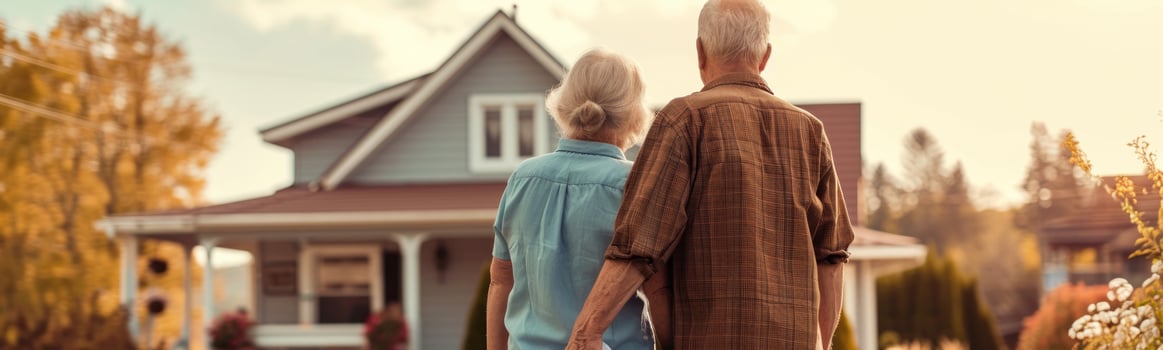 Older couple walking in front of a house holding hands photo