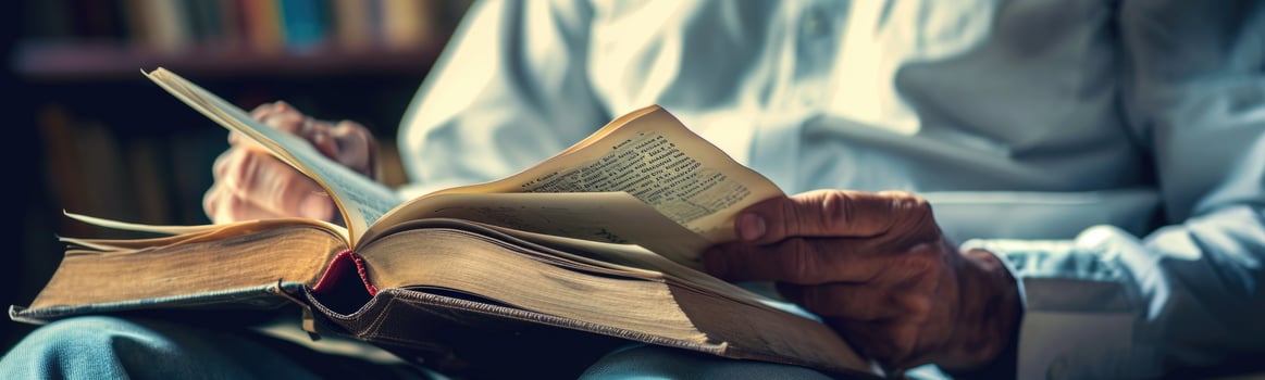 Someone is reading a book while sitting down in a chair photo