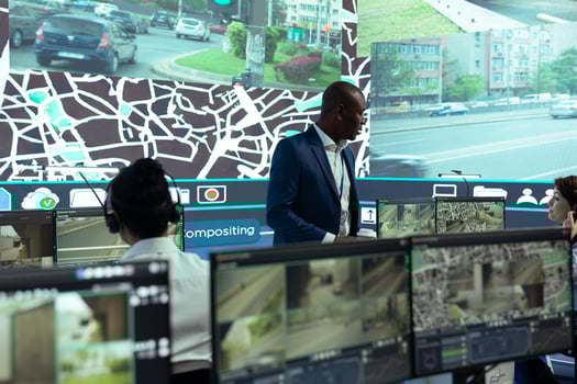 African american supervisor managing his team in control center at shipping agency headquarters, overseeing shipping activities to ensure order and parcel delivery. Working with satellite maps. photo