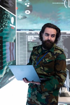 Army soldier reviews targets on a satellite world map to ensure national protection, works with a big screen in military command room. Private examines battlefield real time data for intelligence. photo