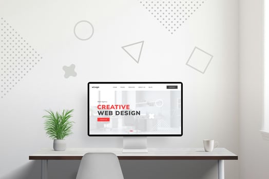 Web design studio presentation on modern computer display on work desk, accompanied by coffee mug and plant for a cozy workspace ambiance photo