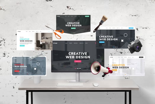 Web pages flying around a web designer's desk and computer display featuring an agency web page presentation. Includes web designer tools, megaphone, wrench key, photo camera, scissors, and brush