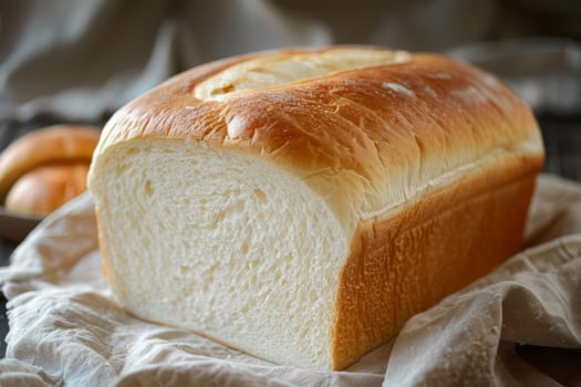 Freshly baked white bread loaf on a light cloth photo