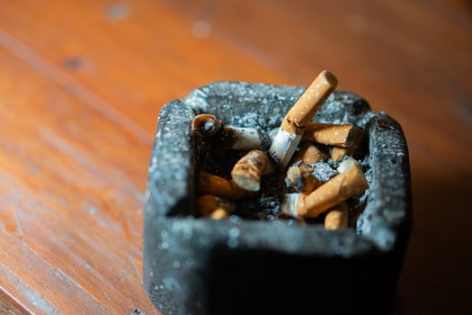 Ashtray with Cigarette Butts on Wooden Table photo