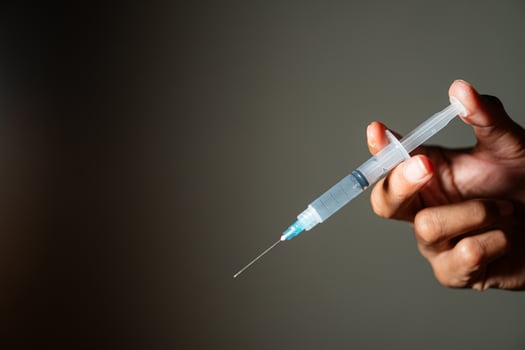 Hand holding a syringe with needle photo