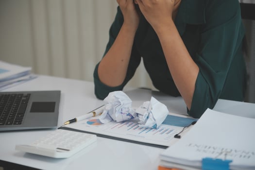Asian women sitting in a home office With stress and eye strain.Tired businesswoman holding eyeglasses and massaging nose bridge. There are tablets, laptops, and coffee. photo